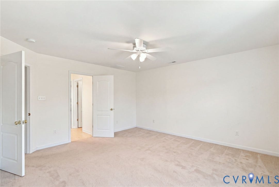 Neutral-toned carpeting, white walls, and a ceiling fan with integrated lighting