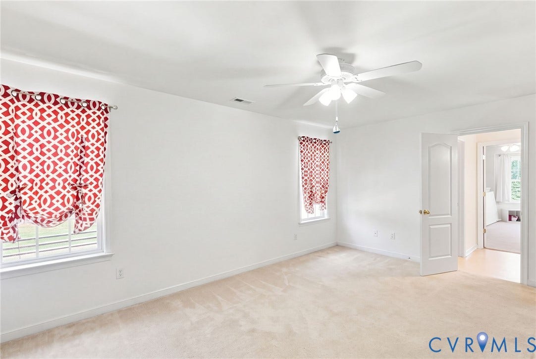 White walls and ceiling, wall-to-wall carpeting, and a ceiling fan with light fixture