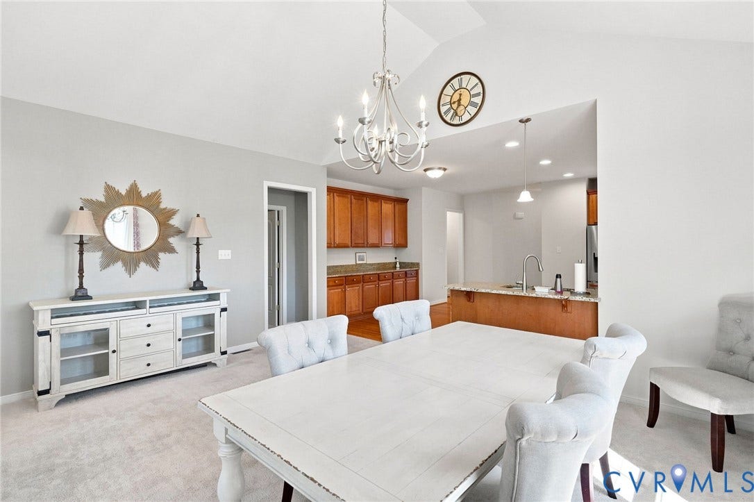 Vaulted ceiling with chandelier lighting, recessed lighting, wood-finish cabinetry, and built-in kitchen peninsula