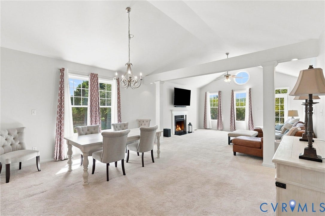 Vaulted ceilings, multiple large windows, and a built-in fireplace with a mantel