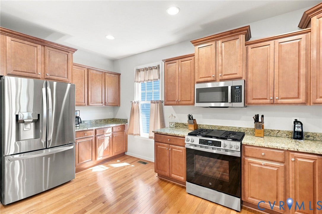 Kitchen featuring stainless steel appliances, wood-finish cabinetry, granite countertops, and recessed lighting