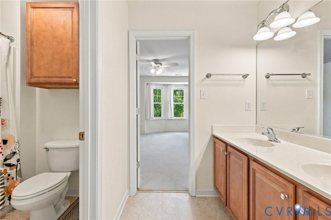 Double vanity with integrated sinks, brushed nickel fixtures, and wood-finish cabinetry