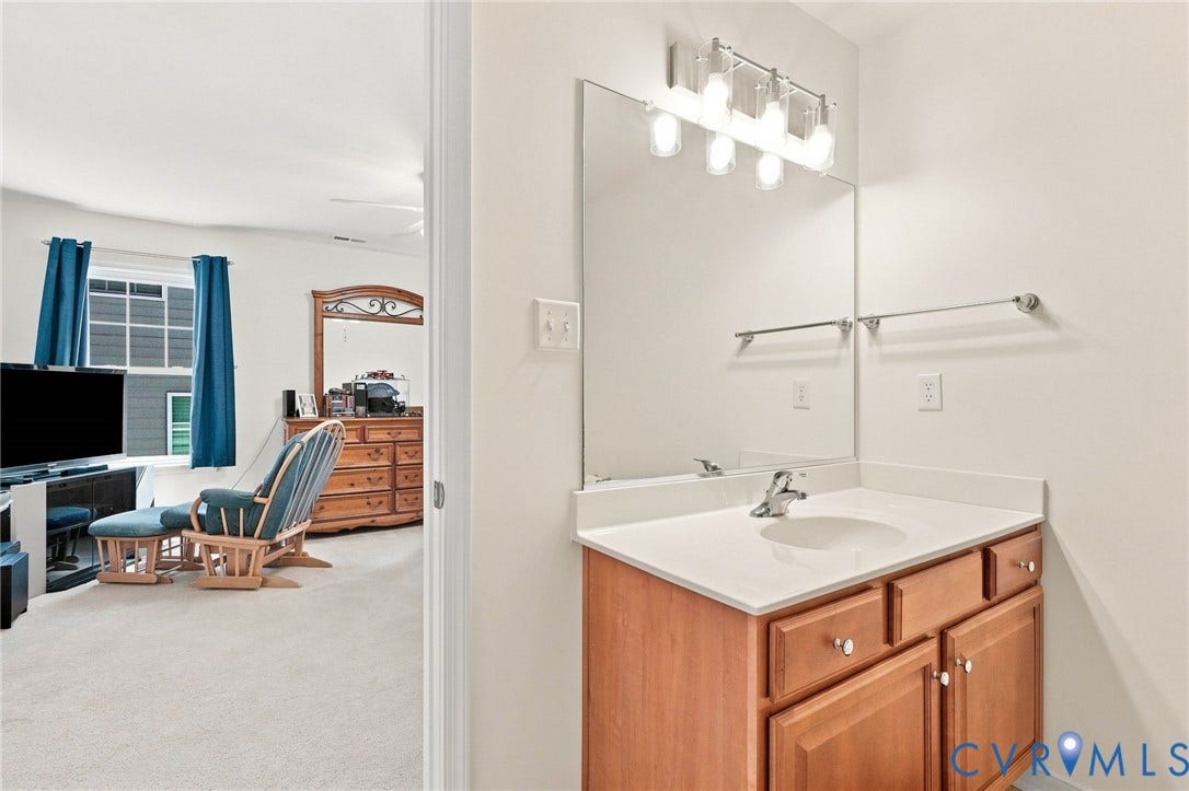 Vanity with a white countertop, undersink cabinetry, and a chrome faucet