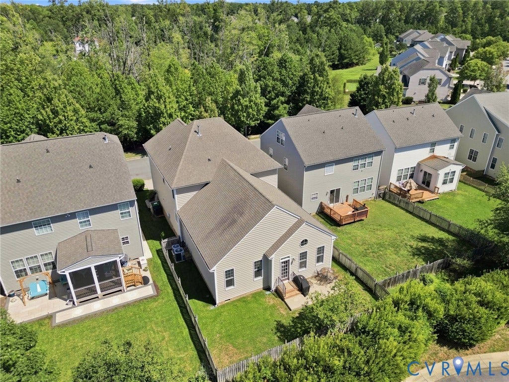 Rear exterior featuring a screened porch, a wood deck, a patio, and a fenced yard