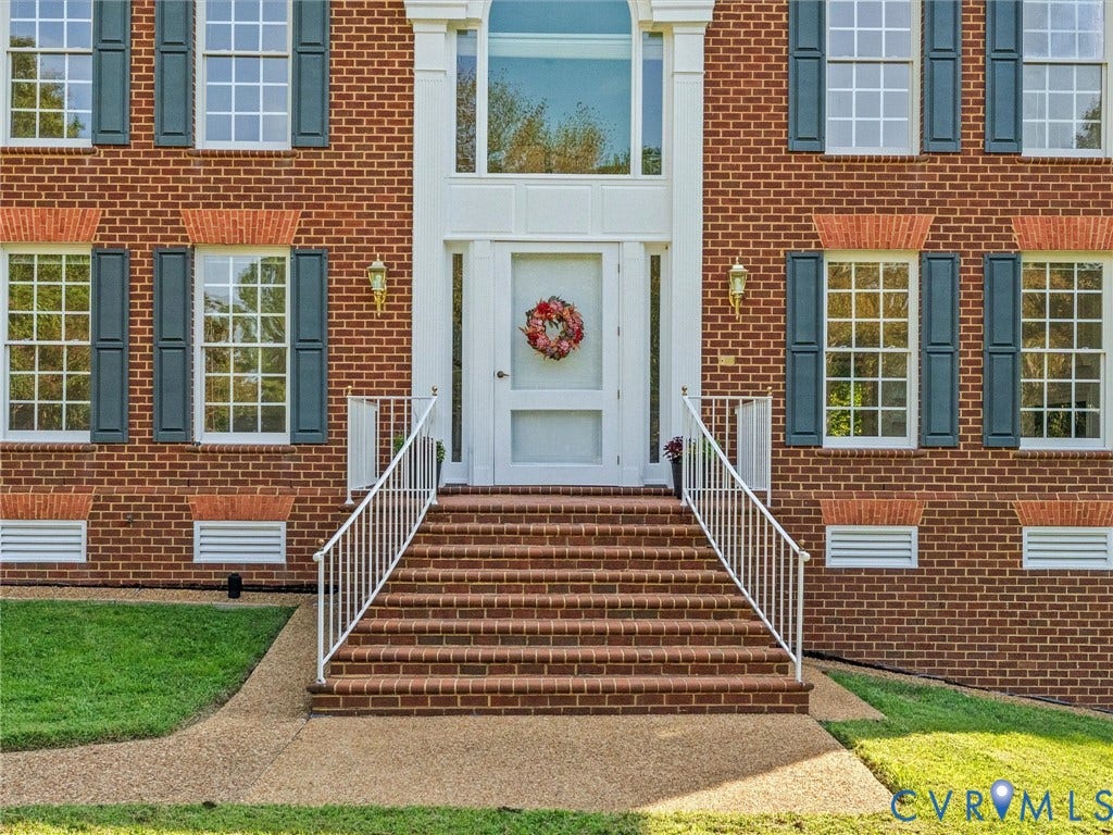 Brick facade with white window trim and dark shutters