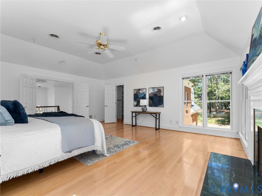 Vaulted ceiling, recessed lighting, ceiling fan, wood-finish flooring, and a fireplace with a dark stone hearth