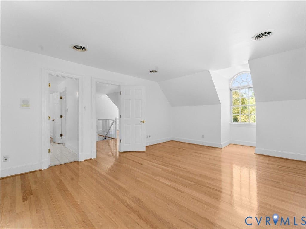 Access to Jack and Jill bath, Hardwood flooring, arched window, white paneled doors, and sloped ceiling