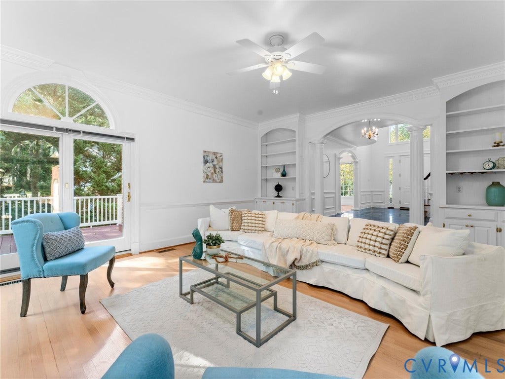 Hardwood flooring, arched doorway, built-in shelving, glass patio doors, and arched transom window