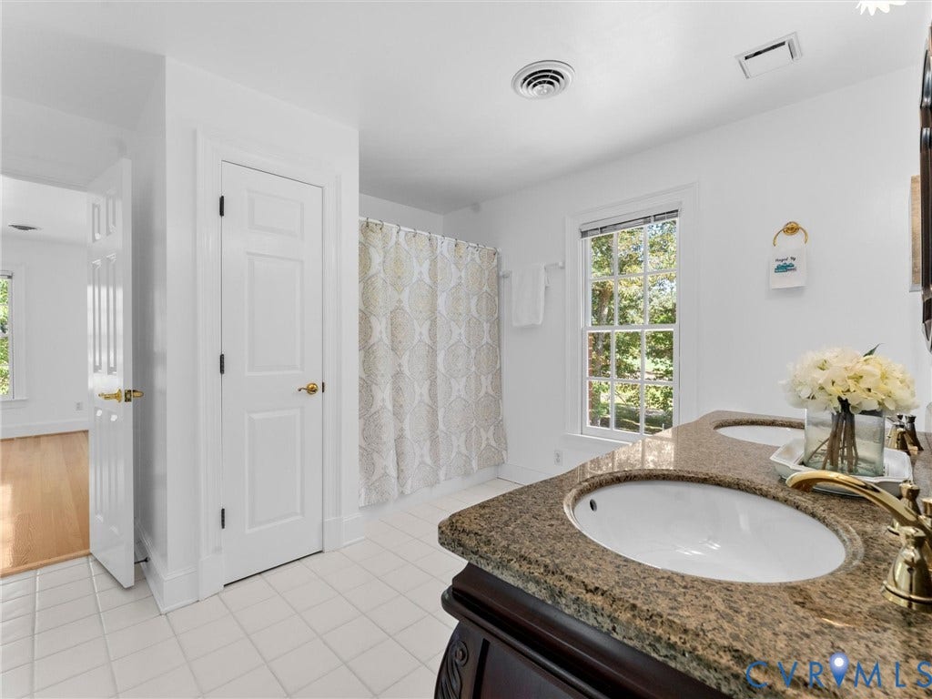 Dual undermount sinks with brass fixtures set in a stone countertop