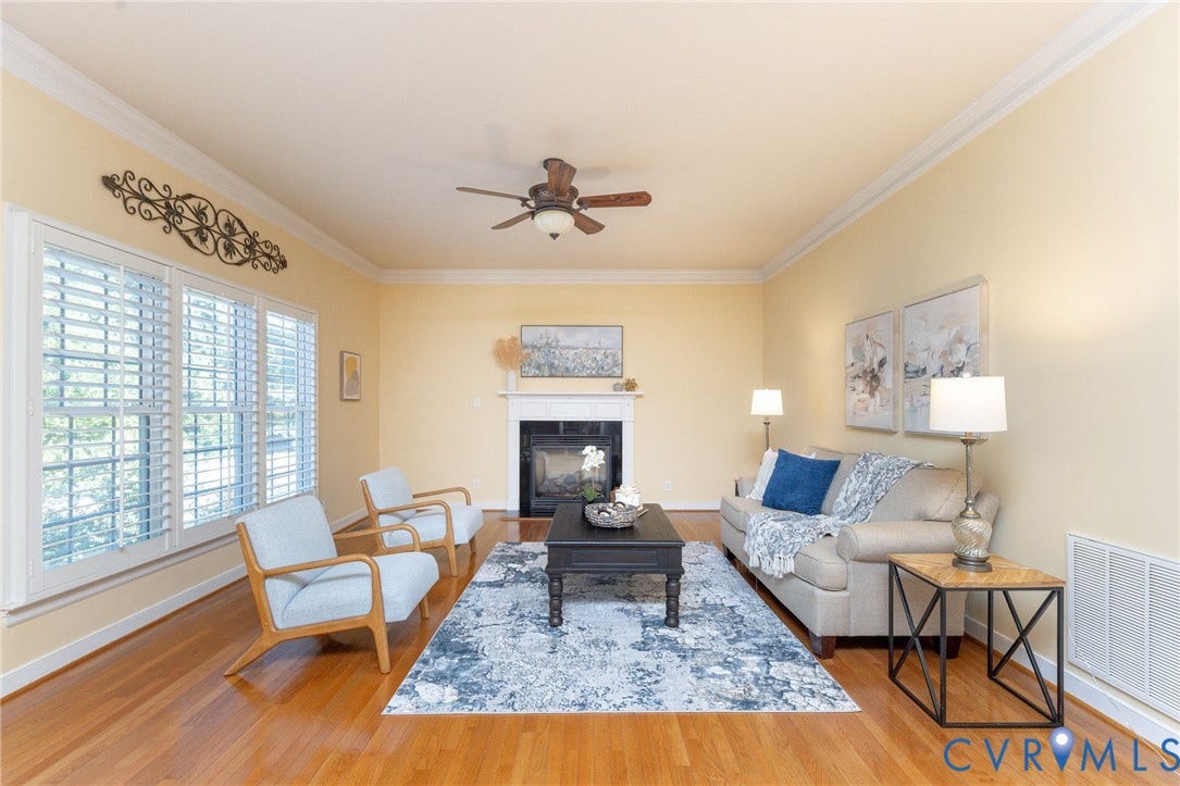 12669 Fawn Lane, Goochland, VA 23233 Hardwood-finish flooring, a fireplace with a white mantel, crown molding, a ceiling fan, and plantation shutters