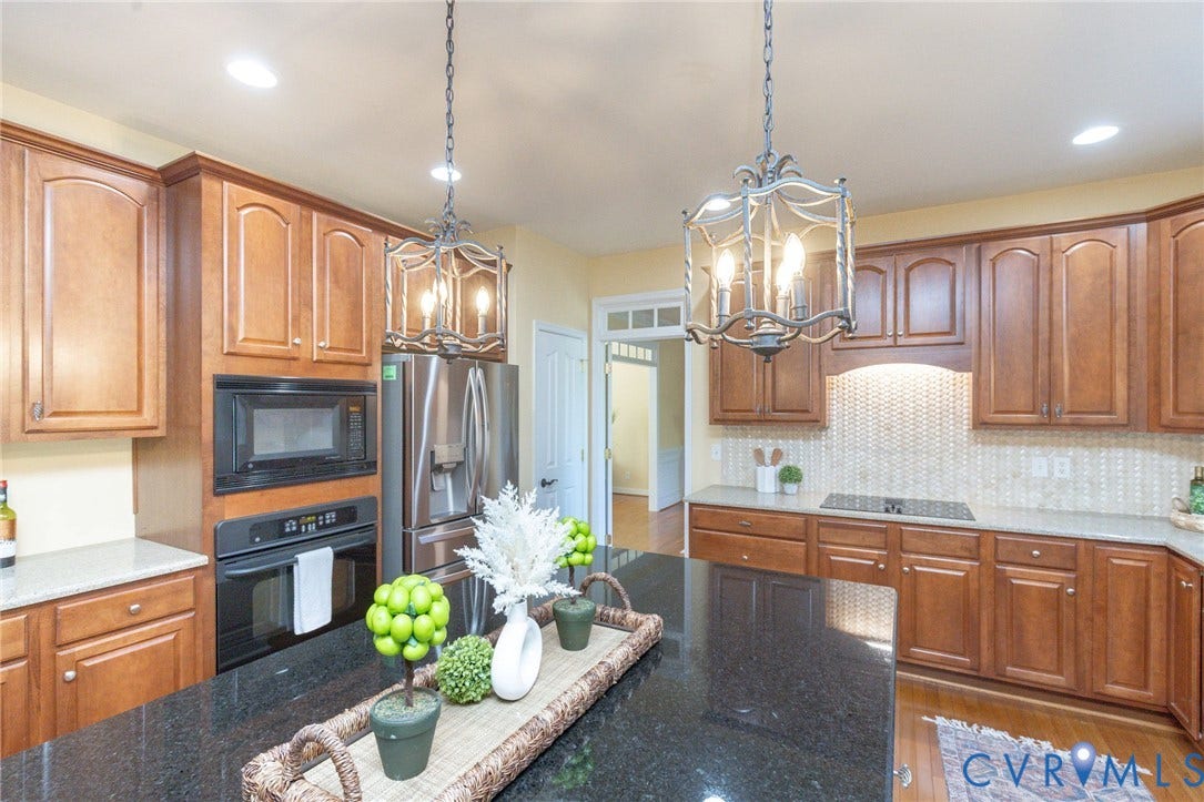 12669 Fawn Lane, Goochland, VA 23233 Expansive kitchen featuring wood cabinetry, stainless steel appliances, a tile backsplash, and a large center island with a dark countertop