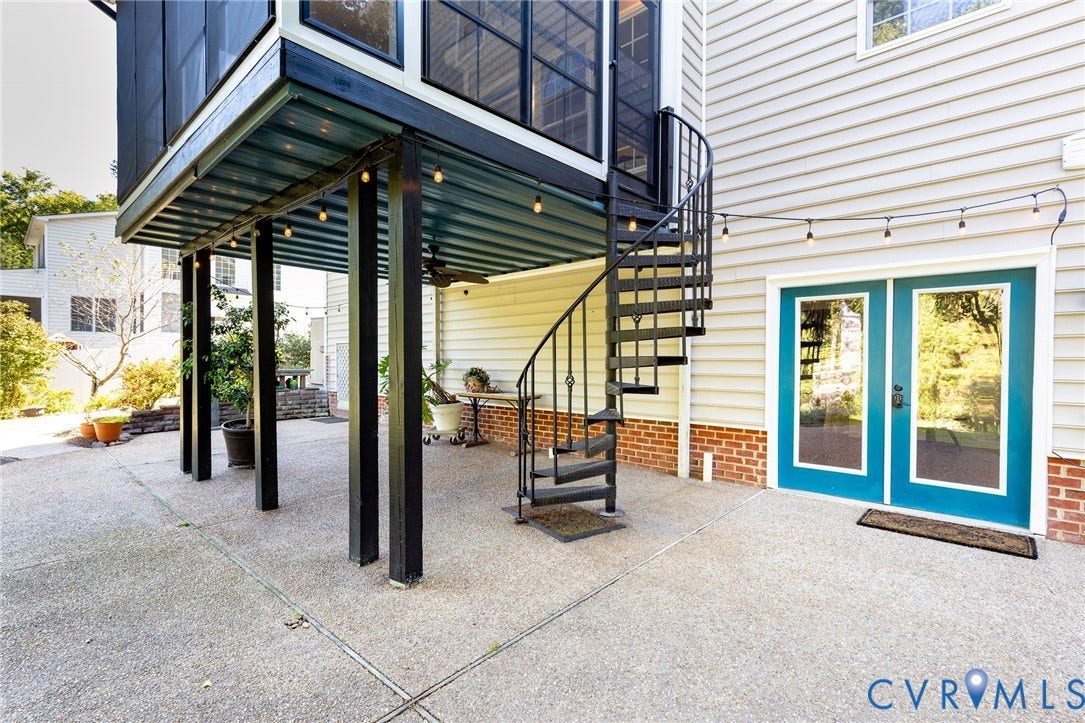 12669 Fawn Lane, Goochland, VA 23233 Screened elevated balcony, spiral staircase, double glass-paneled doors, exposed aggregate concrete patio, and brick foundation