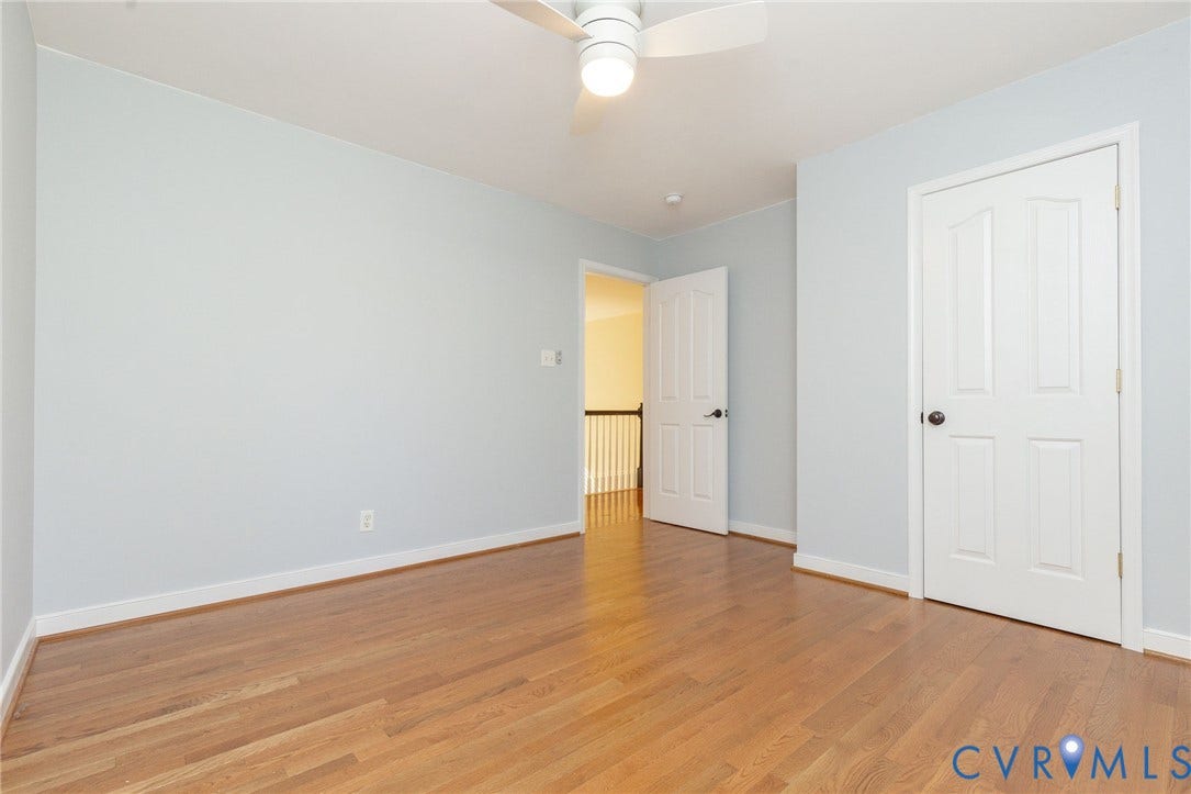 12669 Fawn Lane, Goochland, VA 23233 Wood-finish flooring, light-toned wall paint, white trim, white paneled doors, and a ceiling fan with integrated lighting
