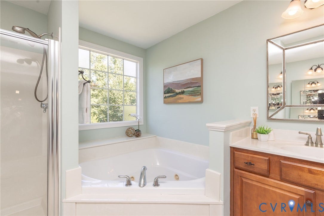 12669 Fawn Lane, Goochland, VA 23233 Built-in soaking tub, separate glass-enclosed shower, wood-finish vanity with countertop, framed mirror, and natural light window