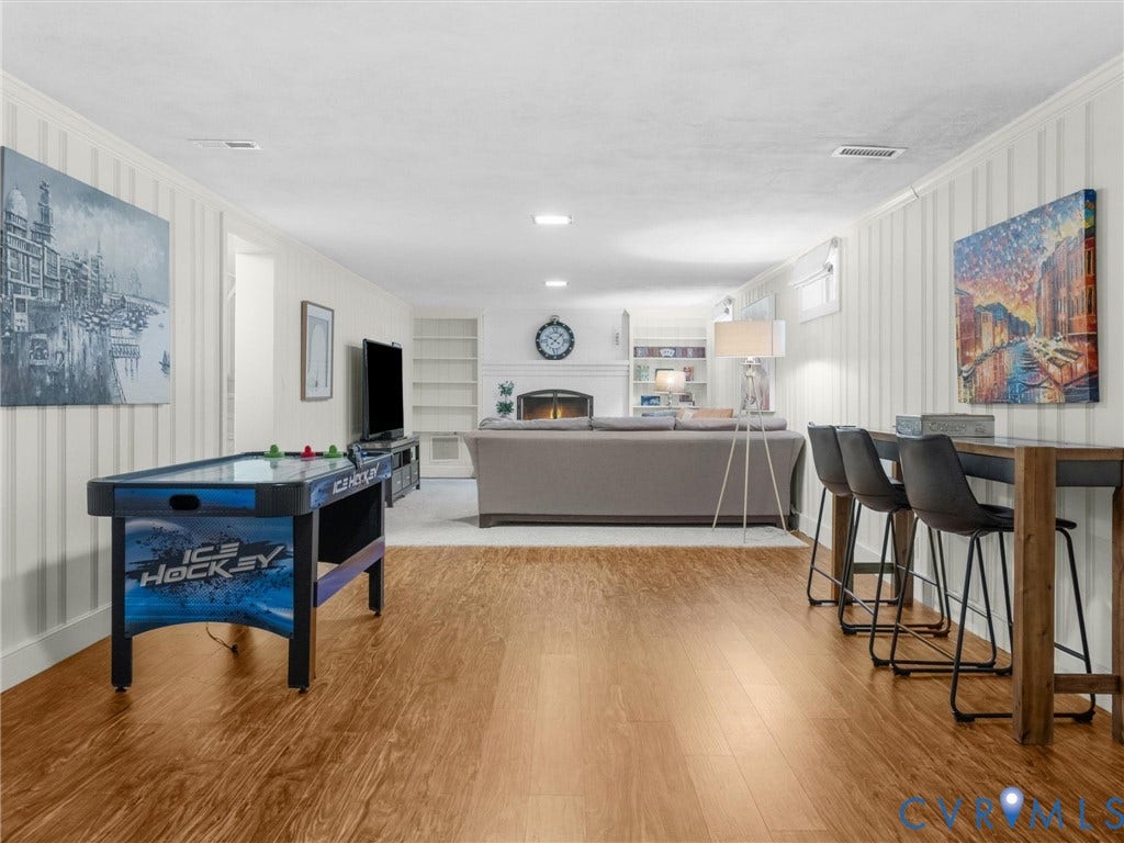 600 Baldwin Road, Henrico, VA 23229 Expansive room featuring wood-finish flooring, white paneled walls, recessed lighting, and a built-in fireplace with white mantel and shelving