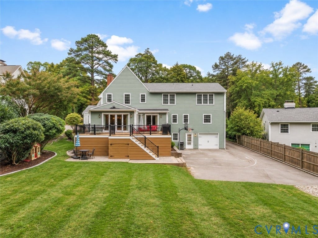 600 Baldwin Road, Henrico, VA 23229 Expansive green lawn with mature landscaping, multi-level deck, direct garage access, and a paved driveway
