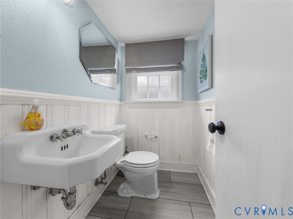 600 Baldwin Road, Henrico, VA 23229 White wall-mounted sink with chrome fixtures, white wainscoting, and gray tile flooring