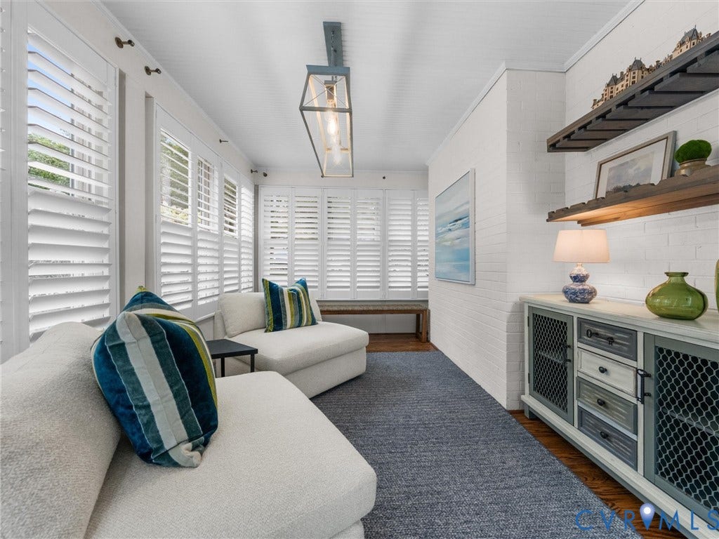 600 Baldwin Road, Henrico, VA 23229 White plank shuttered windows, recessed ceiling, wood-finish flooring, white painted brick wall, and a linear pendant light fixture