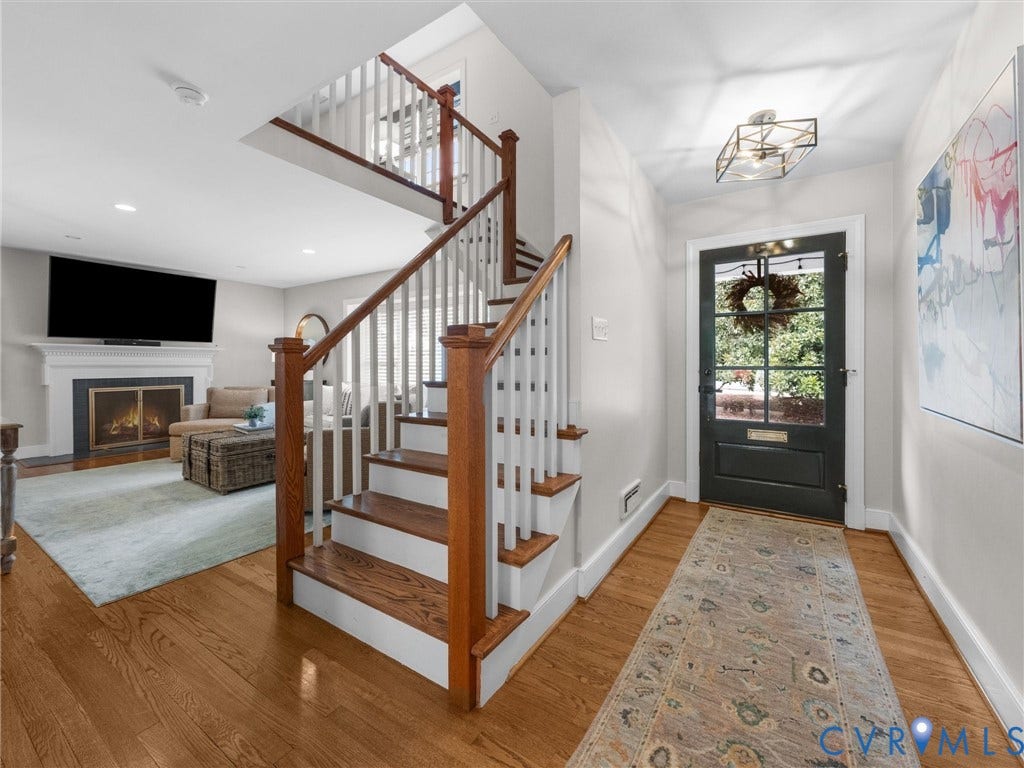 600 Baldwin Road, Henrico, VA 23229 Hardwood flooring throughout, a traditional fireplace with a white mantel, and a dark paneled front door with multiple glass panes