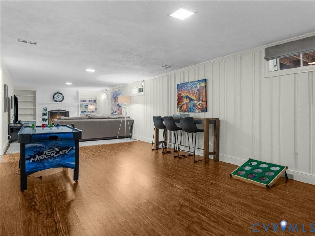 600 Baldwin Road, Henrico, VA 23229 Recessed lighting, wood-finish flooring, fireplace with white mantel, built-in shelving, and board-and-batten wall detailing
