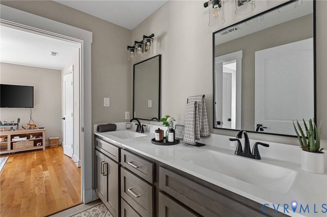 13003 Farrington Place Lane, Farrington Place, Hanover, VA 23059 Double vanity with integrated sinks, dark wood-finish cabinetry, contemporary matte black faucets, and rectangular framed mirrors