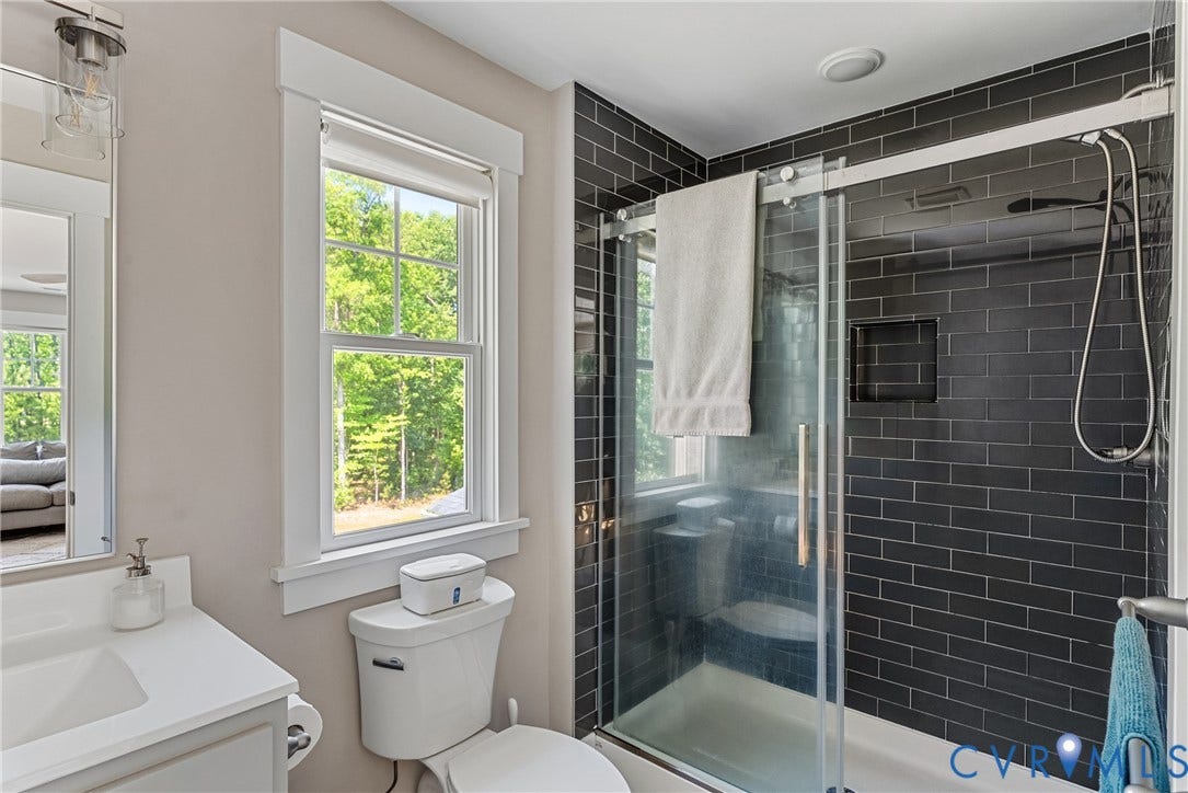 13003 Farrington Place Lane, Farrington Place, Hanover, VA 23059 Glass-enclosed shower with dark subway tile, recessed shower niche, and a sliding glass door