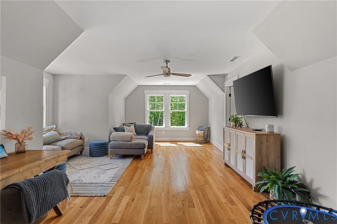 13003 Farrington Place Lane, Farrington Place, Hanover, VA 23059 Expansive room featuring light wood-finish flooring, multiple windows, a ceiling fan, and sloped ceiling details
