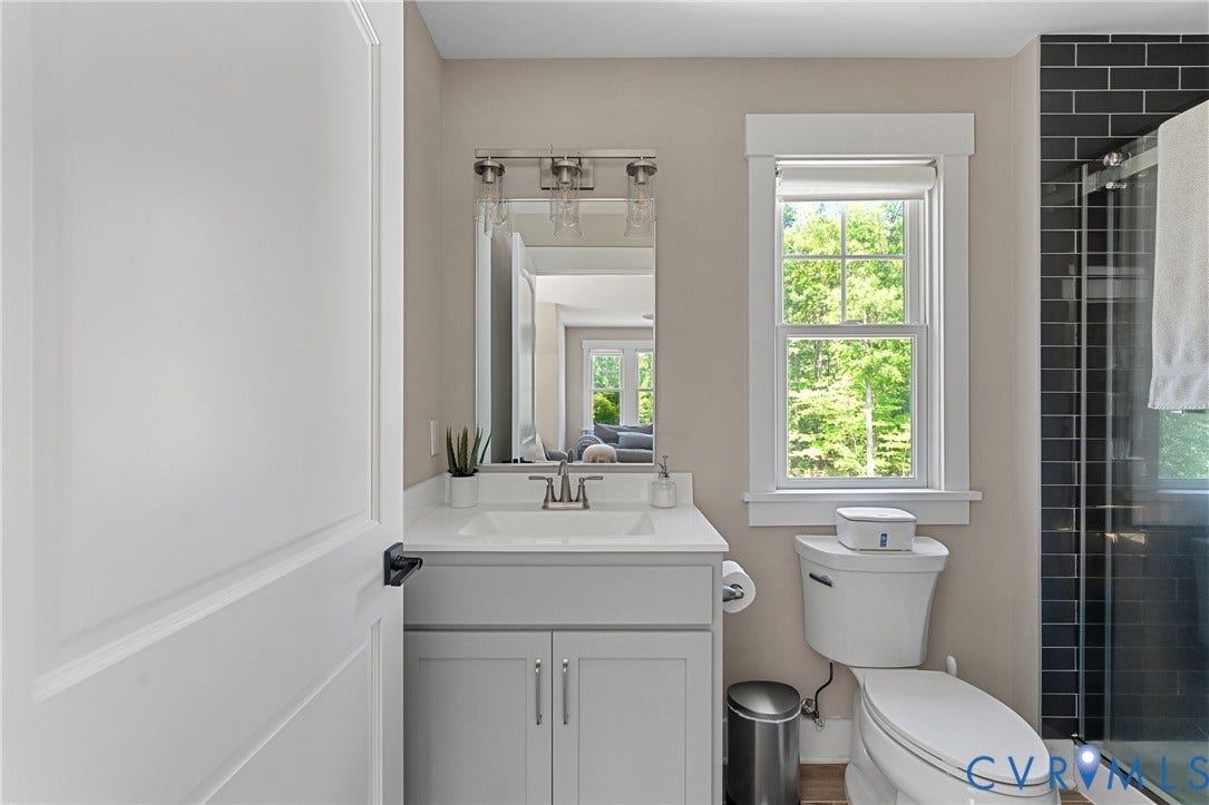 13003 Farrington Place Lane, Farrington Place, Hanover, VA 23059 Bathroom featuring a single vanity with a white countertop, chrome faucet, wall-mounted mirror, and a window with white trim
