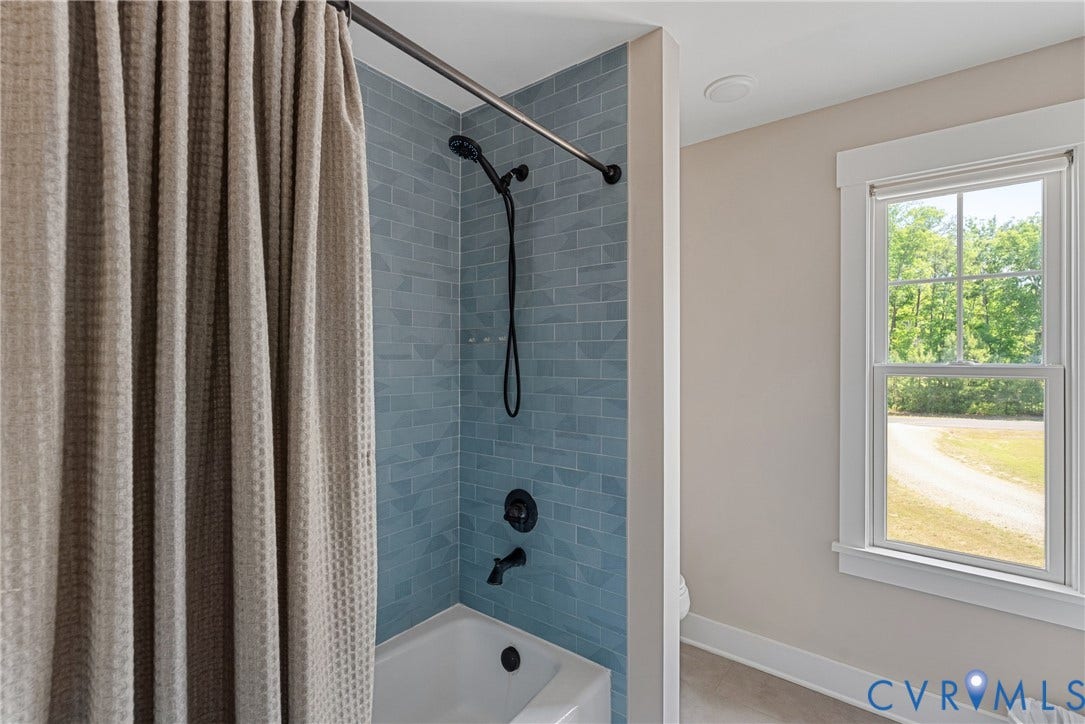 13003 Farrington Place Lane, Farrington Place, Hanover, VA 23059 Bathtub and shower combination featuring blue subway tile surround and matte black fixtures