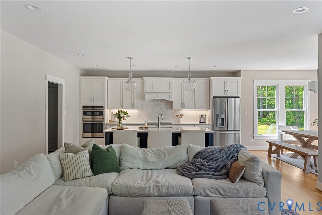 13003 Farrington Place Lane, Farrington Place, Hanover, VA 23059 Open-concept living area featuring recessed lighting, wood-finish flooring, a kitchen island with pendant lighting, white cabinetry, and stainless steel appliances