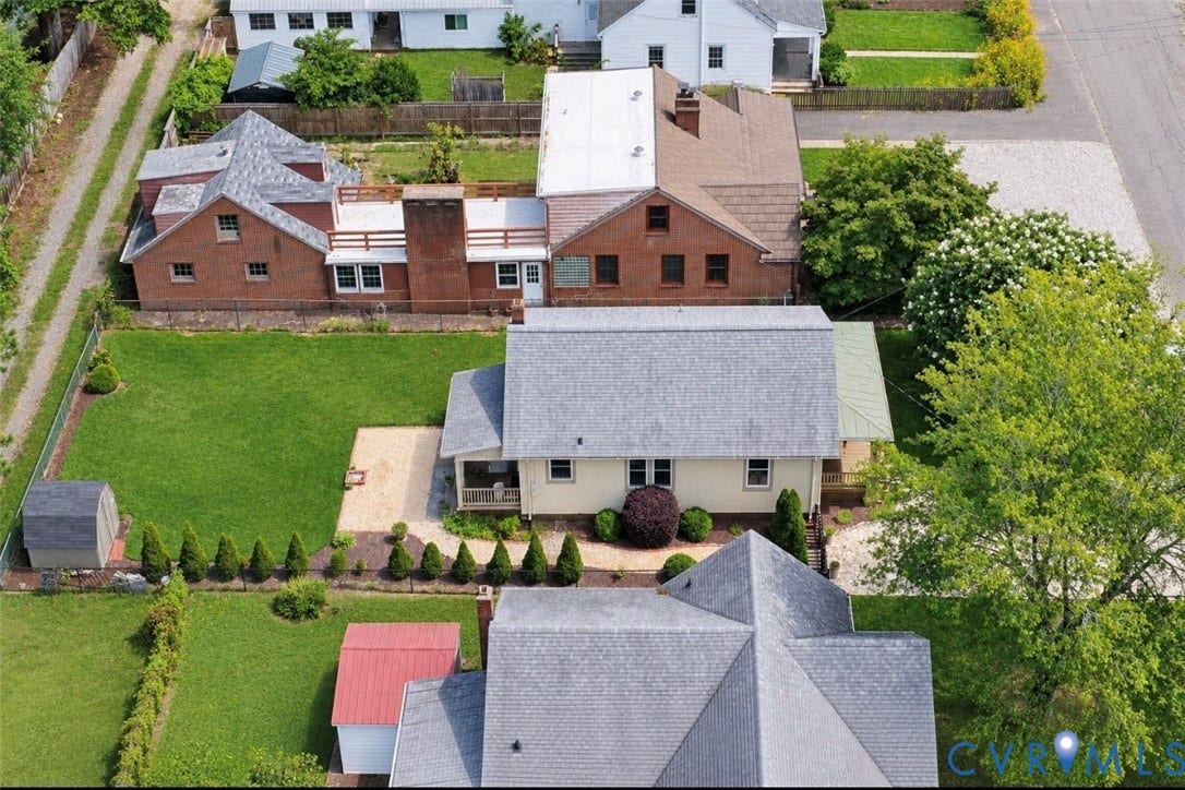 Expansive lot featuring green lawn, gravel patio, and mature landscaping