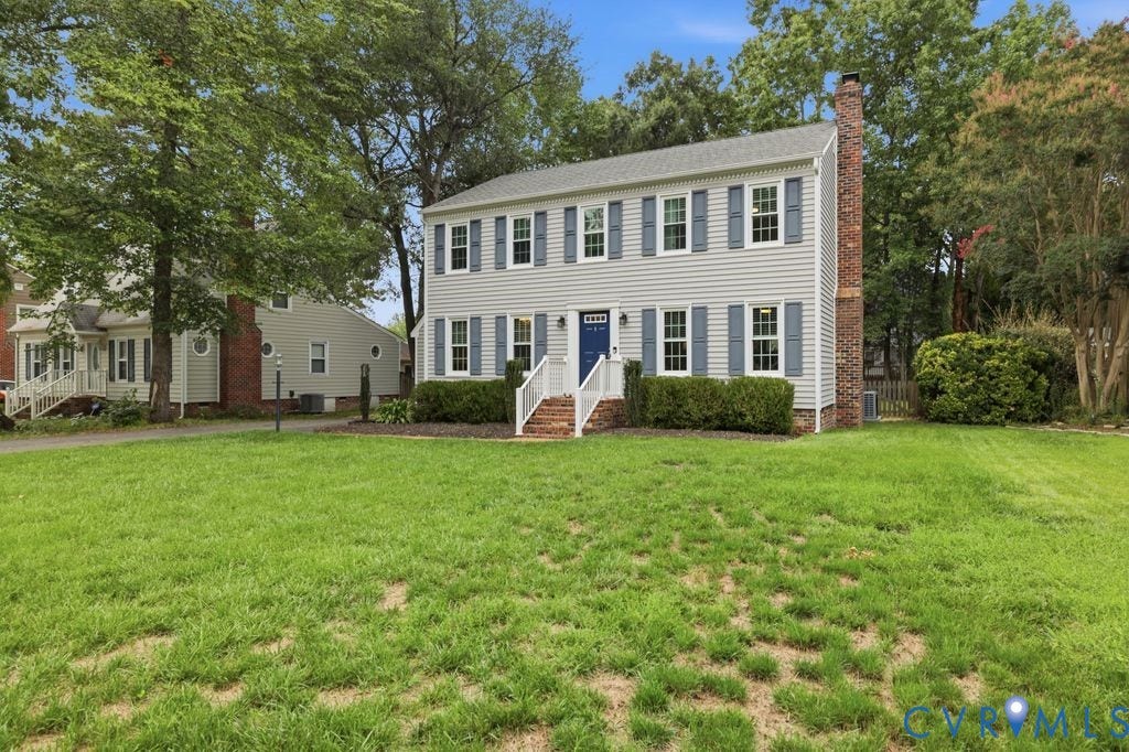 9612 Kingscroft Drive, Glen Allen, VA 23060 Two-story colonial residence featuring light gray siding, a prominent brick chimney, and blue window shutters