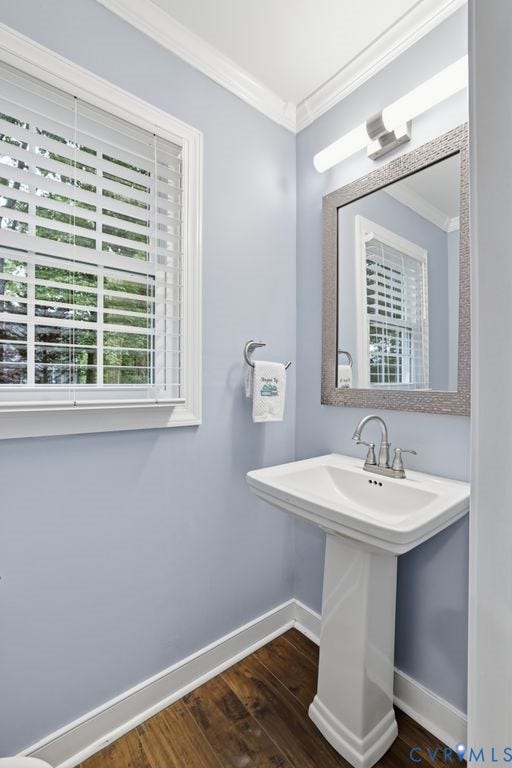 9612 Kingscroft Drive, Glen Allen, VA 23060 Pedestal sink with chrome faucet, wood-finish flooring, light blue wall paint, white trim, and a window featuring white blinds