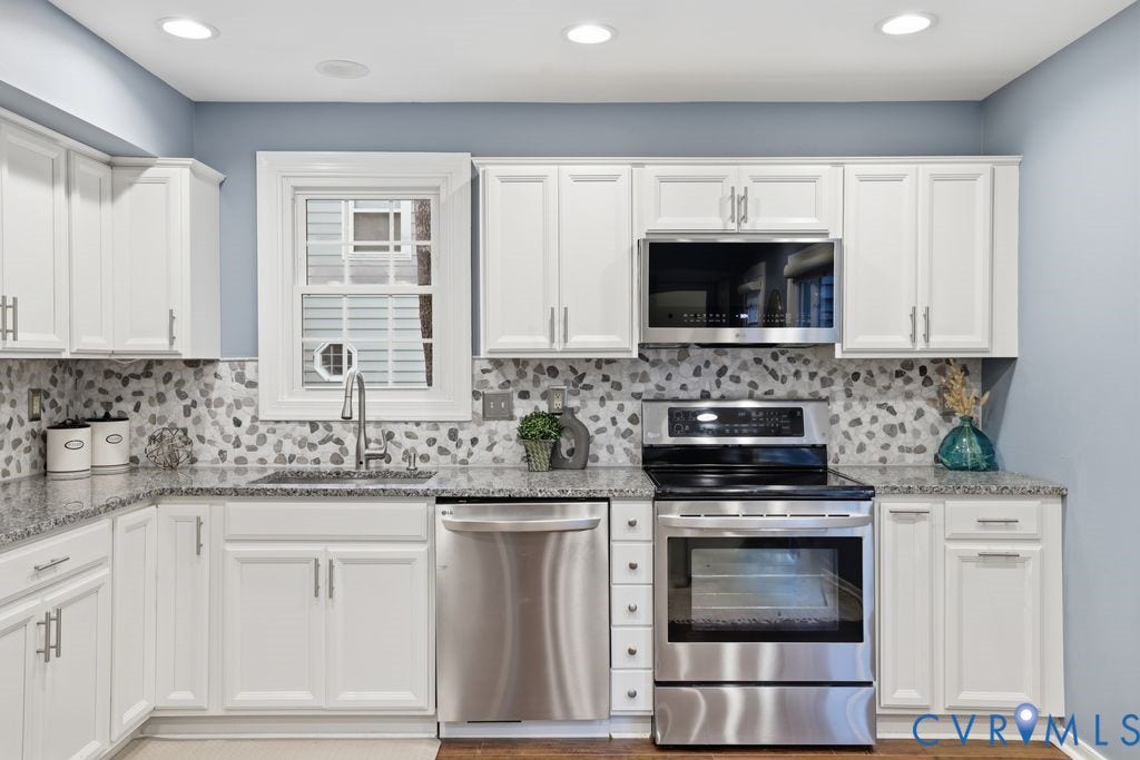 9612 Kingscroft Drive, Glen Allen, VA 23060 Kitchen featuring white shaker-style cabinetry, stainless steel appliances, speckled stone countertops, and a full-height mosaic tile backsplash