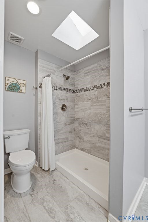 9612 Kingscroft Drive, Glen Allen, VA 23060 Bathroom featuring a skylight, walk-in shower with tiled walls and decorative mosaic accent, white shower pan, and coordinating tile flooring