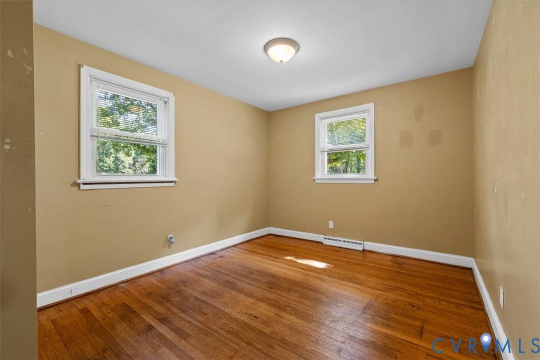 3577 Old Buckingham Road, Powhatan, VA 23139 Hardwood flooring, two windows with white trim, ceiling-mounted light fixture, and neutral wall paint