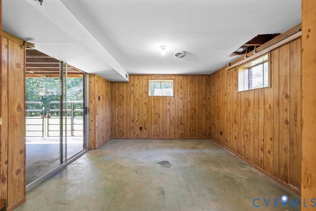 3577 Old Buckingham Road, Powhatan, VA 23139 Wood-paneled room featuring a sliding glass door, two windows, and overhead lighting