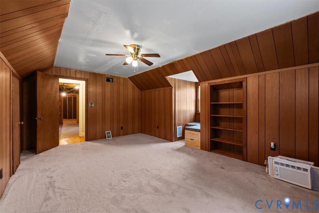 3577 Old Buckingham Road, Powhatan, VA 23139 Carpeted room featuring wood paneling, a built-in bookshelf, and a window seat with storage