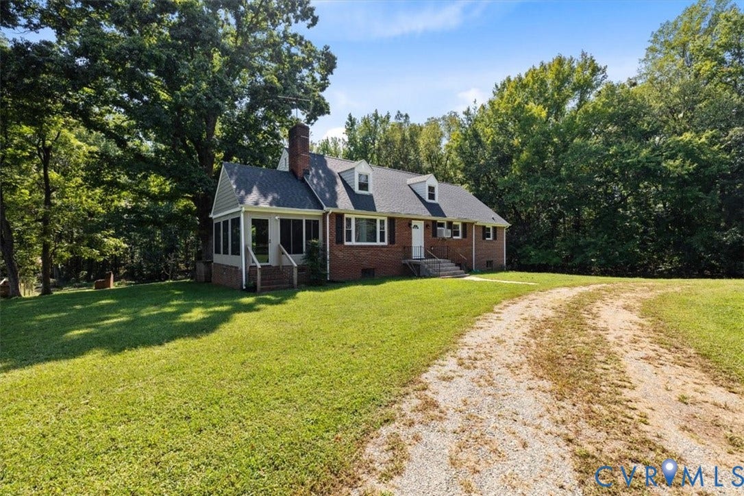 3577 Old Buckingham Road, Powhatan, VA 23139 Brick exterior residence featuring a screened porch, dormer windows, and a gravel driveway