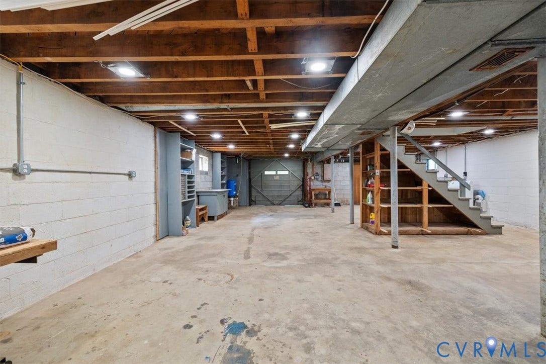 3577 Old Buckingham Road, Powhatan, VA 23139 Unfinished basement with exposed ceiling beams, concrete flooring, block walls, built-in shelving, and utility lighting