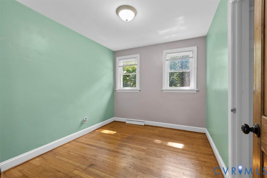 3577 Old Buckingham Road, Powhatan, VA 23139 Hardwood flooring, two windows with white trim, a flush mount ceiling light fixture, and a solid wood door with a black doorknob