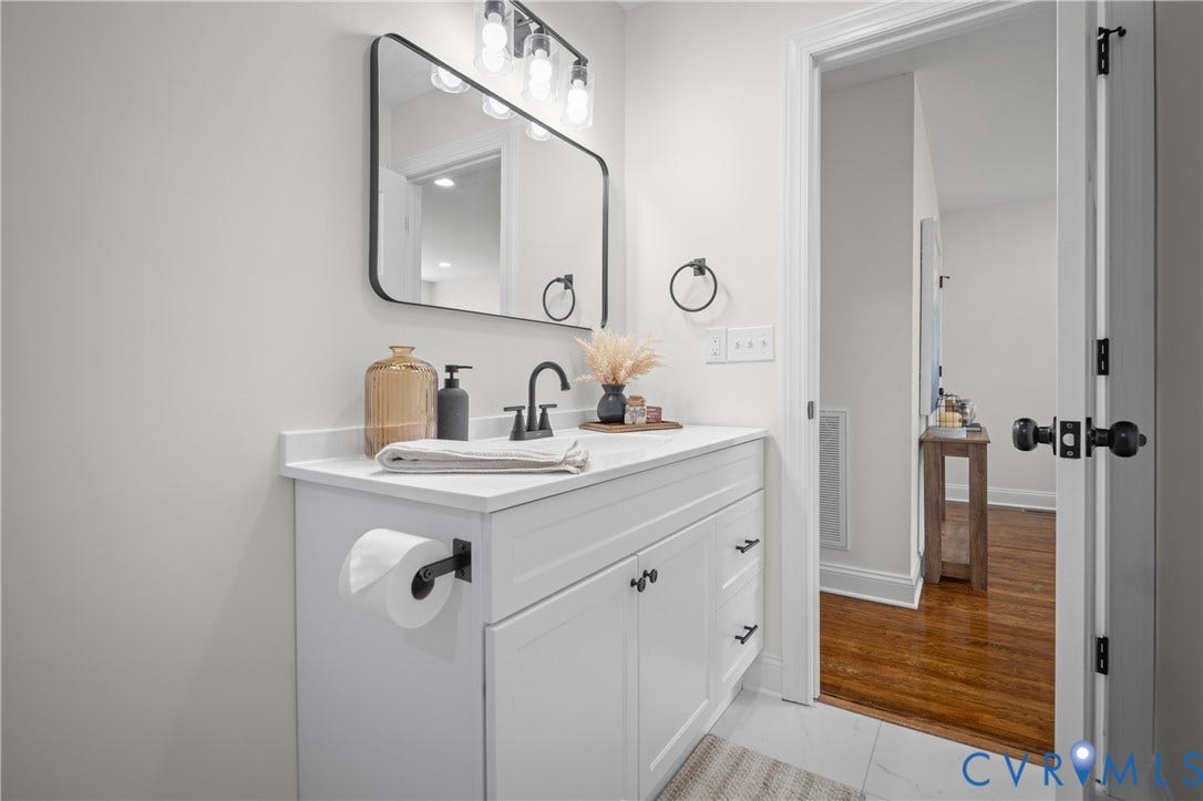 2211 Royall Avenue, Bellemeade, Richmond, VA 23224 White vanity with matte black hardware, integrated sink, and wall-mounted light fixture