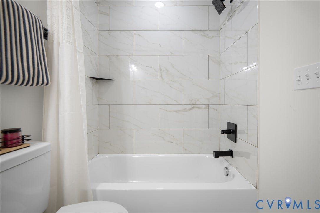 2211 Royall Avenue, Bellemeade, Richmond, VA 23224 White bathtub with matte black fixtures, integrated storage shelf, and subway tile surround