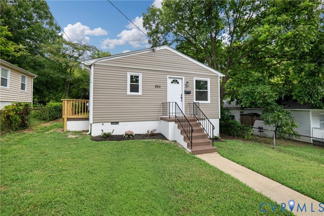 2211 Royall Avenue, Bellemeade, Richmond, VA 23224 Siding exterior, white trim windows, front entry with steps and handrails, concrete walkway, and a side wooden deck