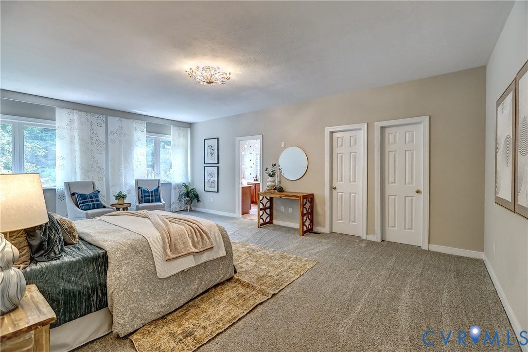 Spacious room featuring multiple windows, neutral wall tones, textured carpeting, and a flush-mount ceiling light