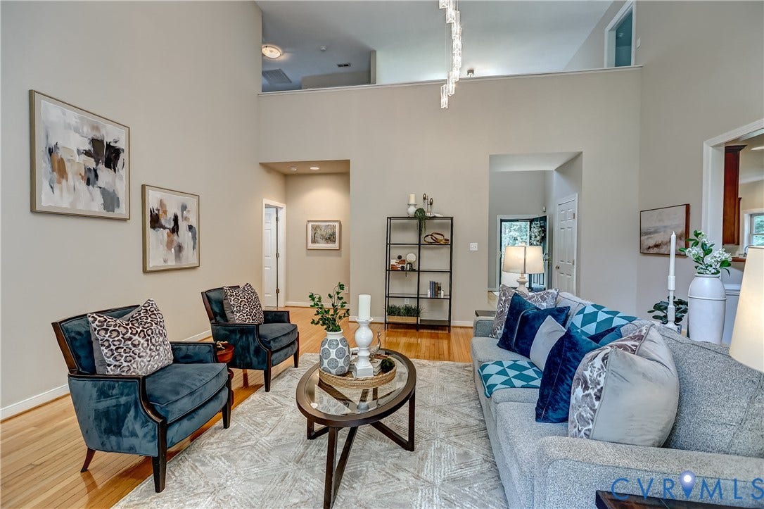 Two-story ceiling, recessed lighting, wood-finish flooring, interior archway, and a contemporary linear chandelier