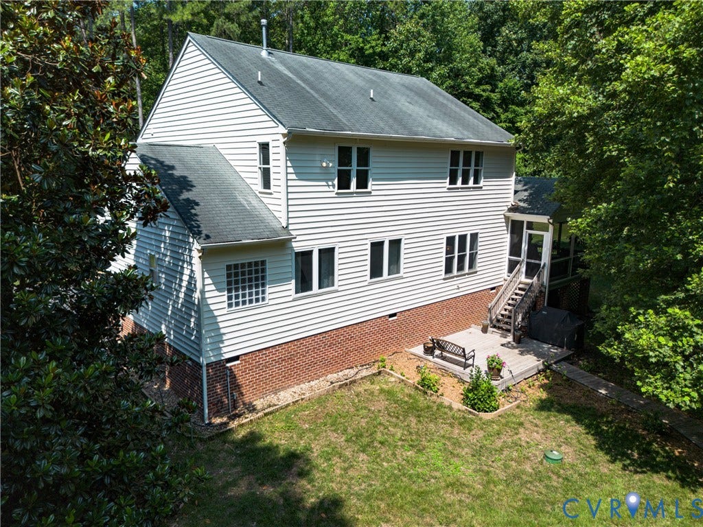 Two-story residence featuring white siding, brick foundation, and multiple windows