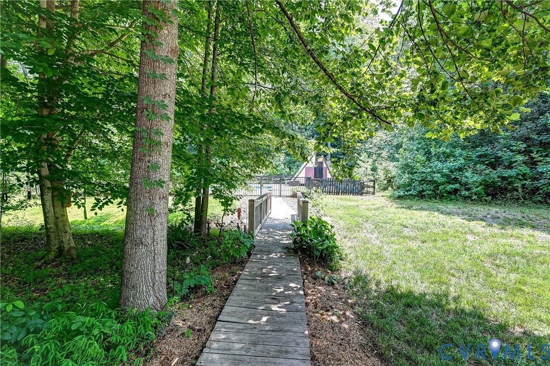 Wood decking pathway with railings leading to an open grassy area