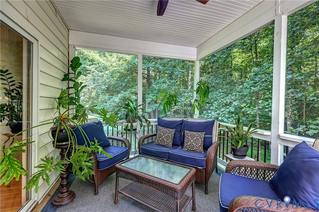 Screened porch featuring a ceiling fan, white siding, and sliding glass door