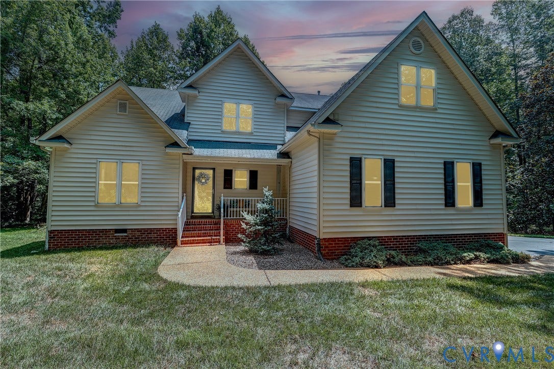 Gable rooflines with light-toned siding, brick foundation, and dark shutters